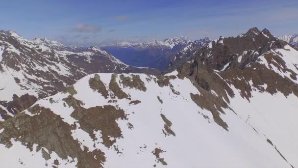 Aerial: latanie nad ogromnymi skalistymi górami wczesną wiosną — Wideo stockowe