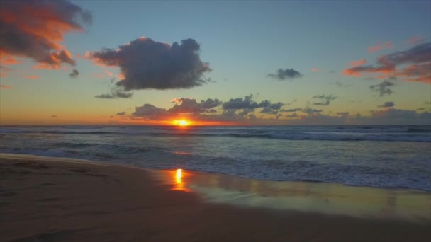 Bølger som ruller opp sandstranden ved solnedgang. – stockvideo