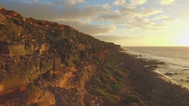 AERIAL: Flying pass high rocky cliff above the ocean — Stock Video