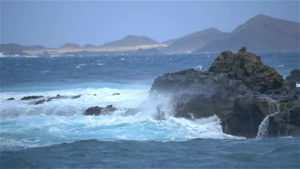 MOCIÓN LENTA: Mar áspero golpeando contra las rocas y salpicando alto — Vídeo de stock