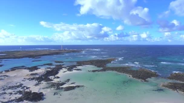 Antenn: flyger över vackra blå laguner mot fyren — Stockvideo
