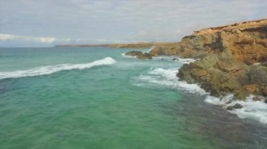 Havadan: Kayalık uçuruma sıçrayan dalgalı okyanusun üzerinde uçmak