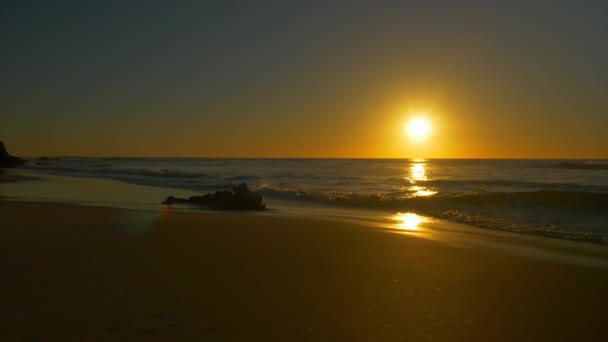 Antenne: oceaan golven en nat zand mousserend in zonsondergang zon — Stockvideo