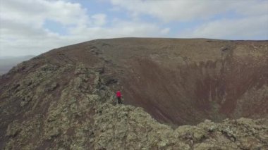 Anten: Volkan kraterinin kenarında duran kadın