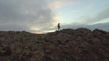 Anten: Volkanik kraterin kenarında yürüyüş eden kadın
