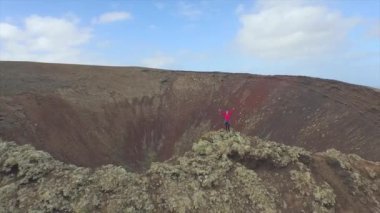 Anten: Volkanik kraterin tepesinde el kaldıran neşeli kadın