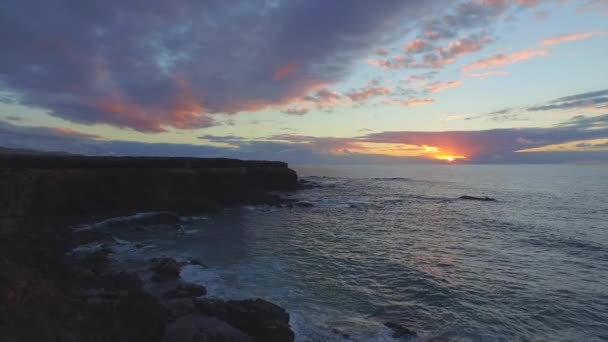 AERIAL: High rocky cliff above the ocean at summer sunset — Stock Video