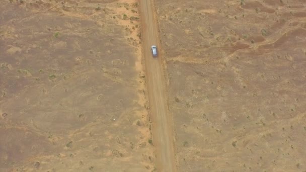 AERIAL: Carro que atravessa enorme deserto arenoso ao lado do oceano — Vídeo de Stock