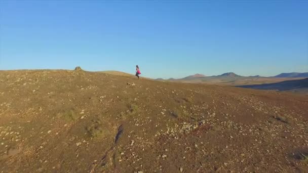 AÉRIAL : Jeune femme sportive faisant du jogging sur la pente du volcan — Video