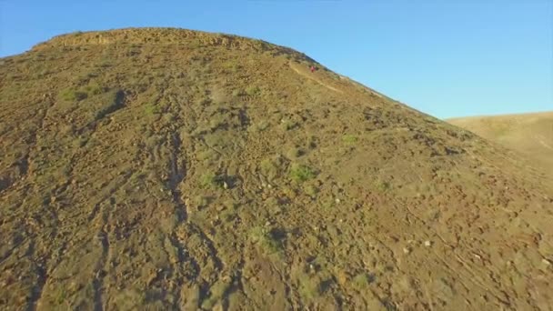 AERIAL: Flying over woman climbing up the volcano — Stock Video