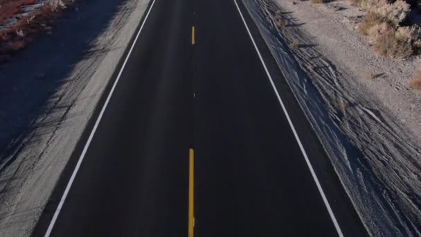 Antena: Estrada vazia grande que leva a altas montanhas majestosas — Vídeo de Stock