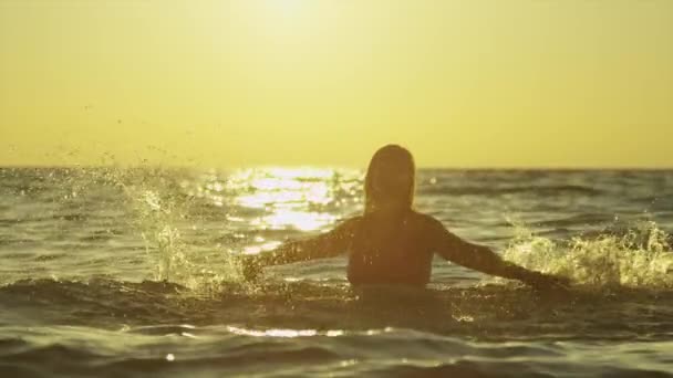 MOTION LENT : Heureuse jeune femme jouant avec l'eau dans l'océan — Video