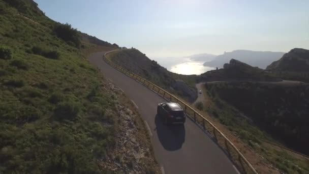 АЭРИАЛ: Автомобиль за рулем по горному перевалу над океаном — стоковое видео