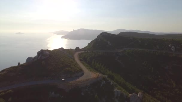 AERIAL: Dirigir ao longo da estrada no topo de falésias oceânicas altas — Vídeo de Stock