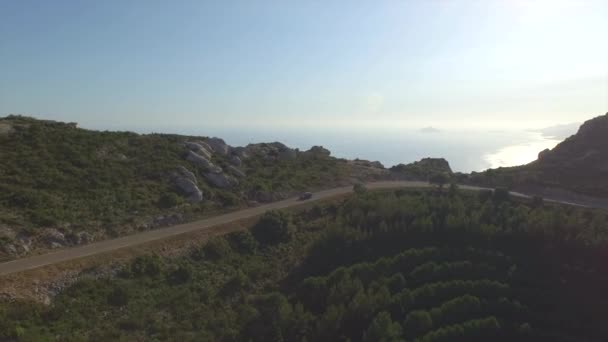 AERIAL: Coche que conduce a lo largo de la carretera del paso de montaña en la noche de verano — Vídeo de stock