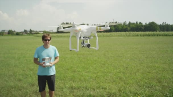 FECHAR UP: Jovem piloto operando helicóptero RC em um campo — Vídeo de Stock