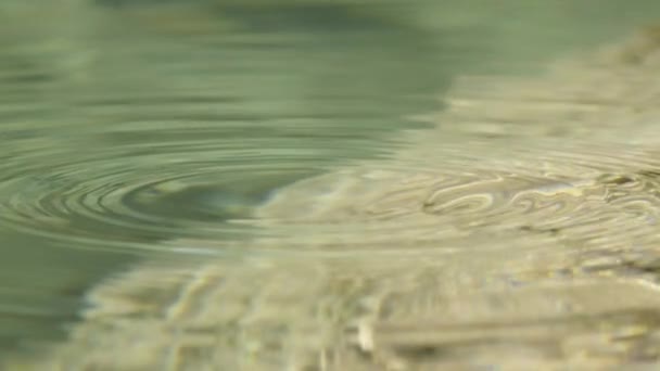 MOVIMIENTO Lento CERRAR: Gota de agua cayendo en el lago de montaña — Vídeo de stock