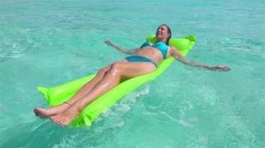 Yavaş Hareket: Mutlu genç kadın şişme su floatie üzerinde yatıyordu