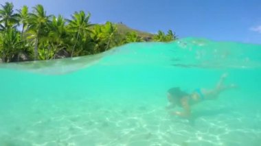 Lüks otel resort önünde okyanusta yüzmeye kadın