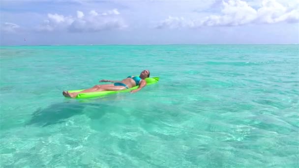 Zeitlupe: Frau entspannt auf aufblasbarem Wasser treibend im Meer — Stockvideo