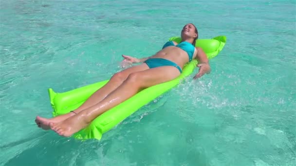 SLOW MOTION: Smiling woman swimming on inflatable airbed in ocean — Stock Video