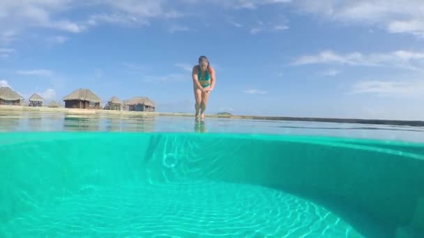 AGUA SUBVENDEDOR: Mujer joven sumergiéndose en la piscina en el complejo de lujo — Vídeos de Stock