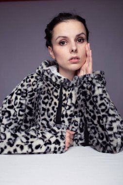 Kapüşonlu kadın, gri arka plan.