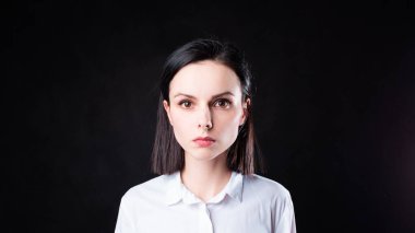 Siyah arka planda beyaz gömlekli kadın.