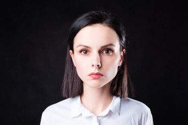 Siyah arka planda beyaz gömlekli kadın.