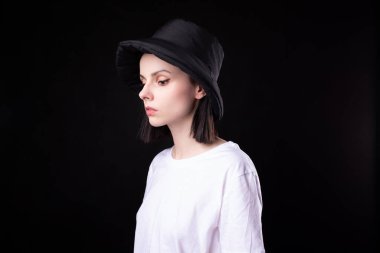 Beyaz tişörtlü ve siyah şapkalı kadın.