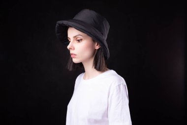 Beyaz tişörtlü ve siyah şapkalı kadın.