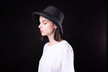 Beyaz tişörtlü ve siyah şapkalı kadın.