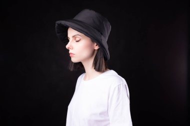 Beyaz tişörtlü ve siyah şapkalı kadın.