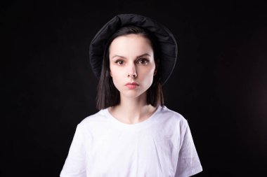 Beyaz tişörtlü ve siyah şapkalı kadın.