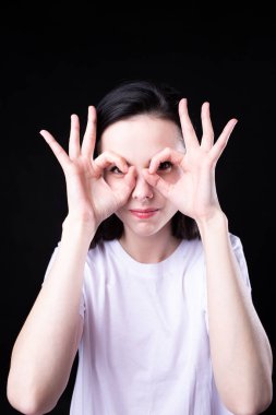 Siyah arka planda beyaz tişörtlü kadın.