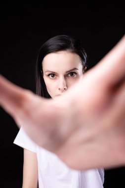 Kadın avucunu öne doğru uzatmış, siyah arka plan.