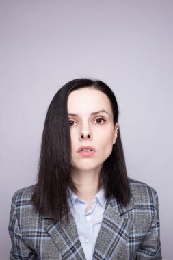 Gri ekose elbiseli kadın yönetici.