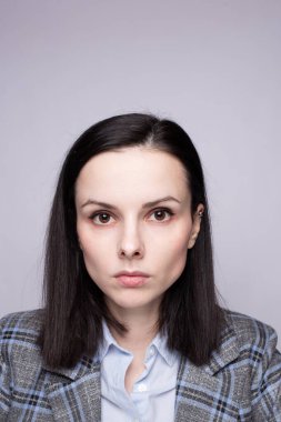 Gri ekose elbiseli kadın yönetici.