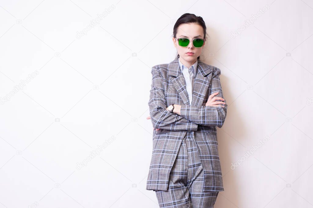 woman in green glasses and gray plaid suit