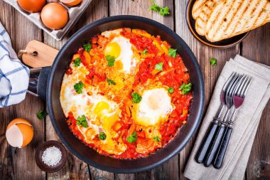Shakshuka. Kızarmış yumurta domates, kırmızı biber ve maydanoz ile