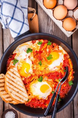 Shakshuka. Kızarmış yumurta domates, kırmızı biber ve maydanoz ile