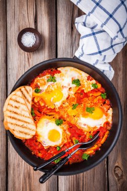 Shakshuka. Kızarmış yumurta domates, kırmızı biber ve maydanoz ile