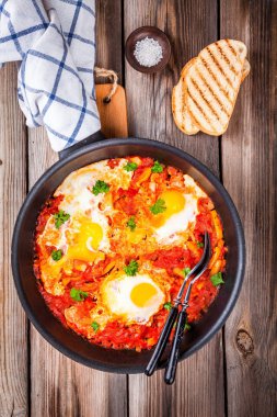 Shakshuka. Kızarmış yumurta domates, kırmızı biber ve maydanoz ile