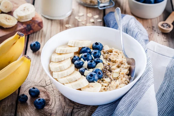 早餐：含香蕉、蓝莓、奇亚种子和杏仁的燕麦 — 图库照片