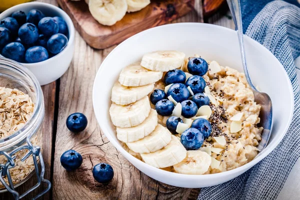 早餐：含香蕉、蓝莓、奇亚种子和杏仁的燕麦 — 图库照片