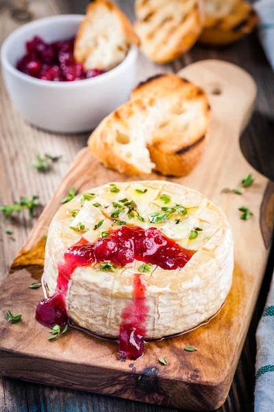 Baked camembert with cranberry sauce and thyme — Stock Photo, Image