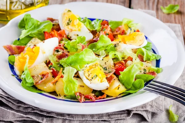 Картофельный салат с яйцами, салатом, помидорами и беконом — стоковое фото