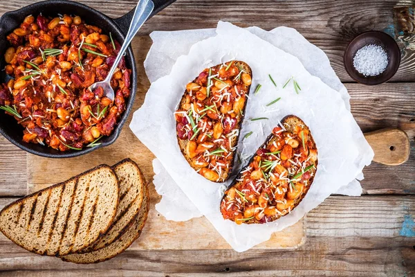 Fagioli al forno con rosmarino e parmigiano sul pane tostato — Foto Stock