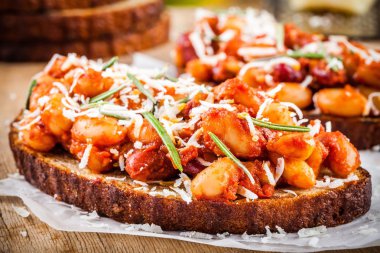 Biberiye ve parmesan ile pişmiş fasulye tost