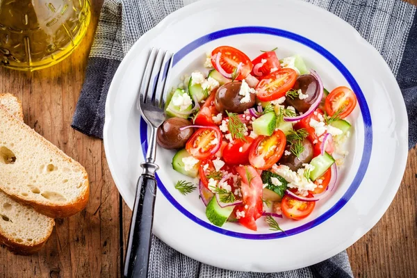 Salada com tomate, pepino, azeitonas, cebola, feta e cuscuz — Fotografia de Stock